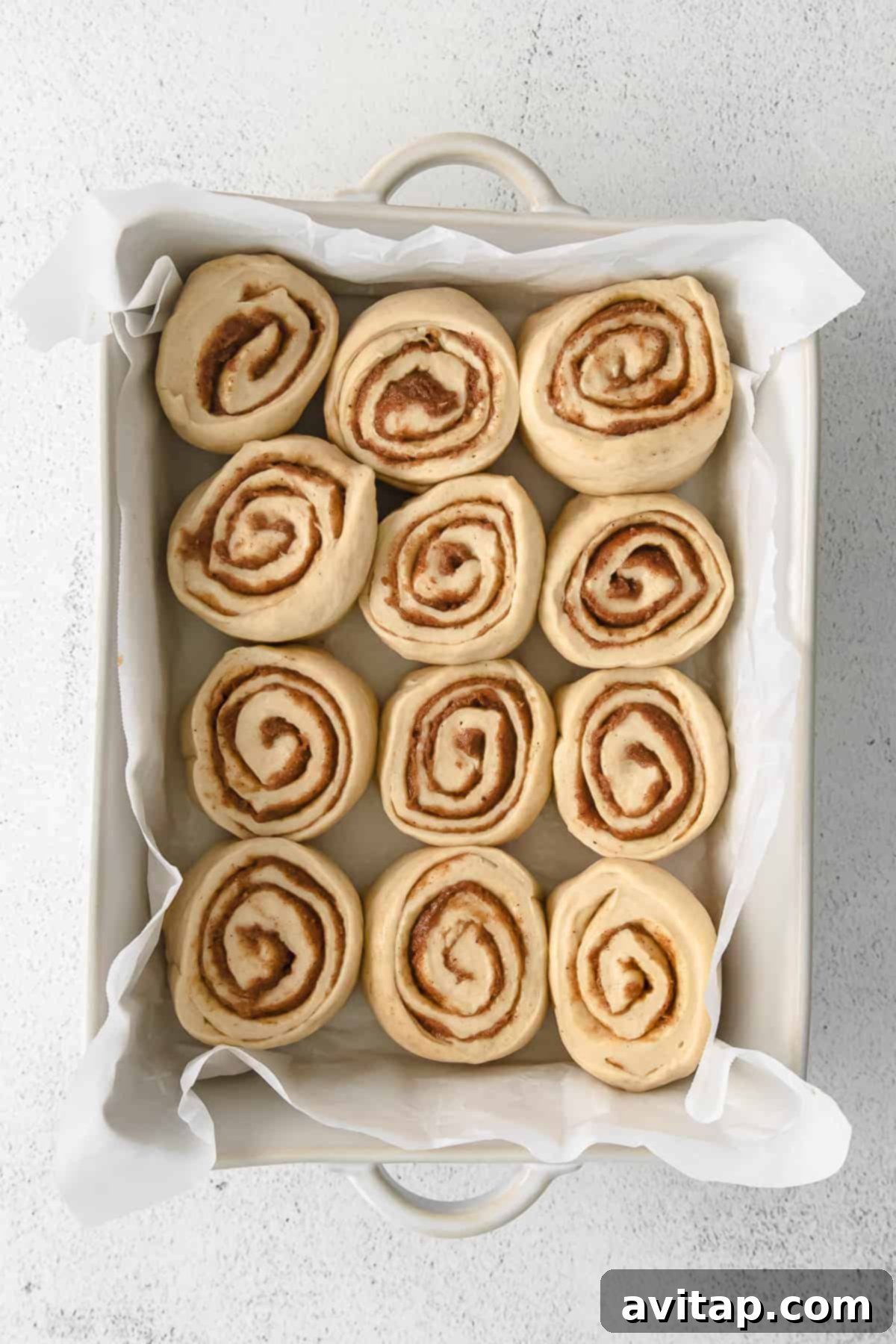 maple cinnamon rolls in a casserole dish ready to be baked to perfection