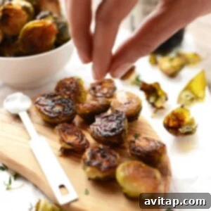 Roasted Brussels sprouts on a wooden cutting board, garnished with sea salt, ready to be served.