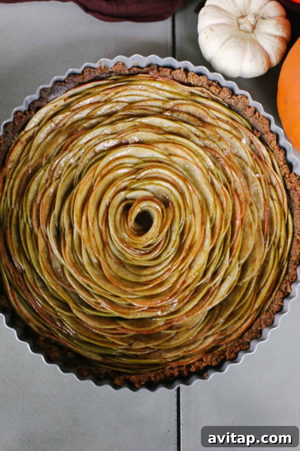 Exquisite Apple Tart A beautifully crafted apple tart, featuring an elegant apple rose design and a golden-brown crust, presented in a tart pan.
