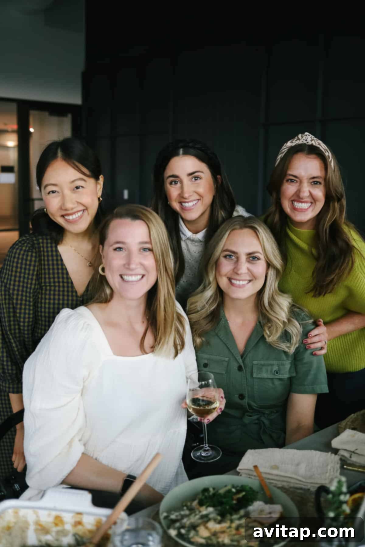Happy Thanksgiving Gatherings Five smiling women enjoying a delightful Thanksgiving meal around a festively decorated table, showcasing the joy of communal dining.