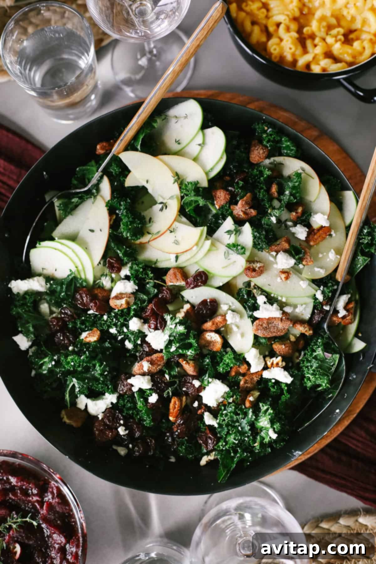Refreshing Thanksgiving Salad A vibrant Thanksgiving salad, with massaged kale, apple slices, nuts, goat cheese, and dried cherries, artfully arranged in a large serving bowl.