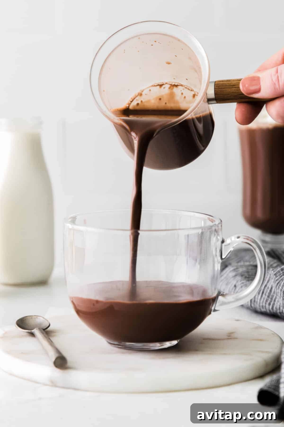 A beautifully prepared mug of Maple Sea Salt Hot Chocolate, topped with whipped cream and a sprinkle of sea salt.