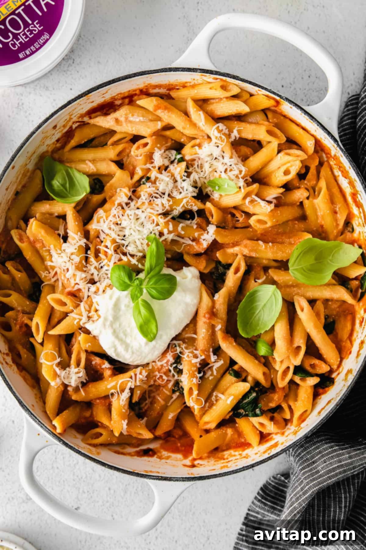 Ricotta pasta in a Dutch oven, garnished with fresh herbs