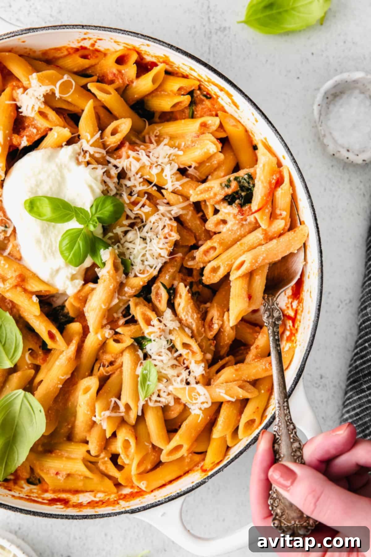 Serving creamy whipped ricotta pasta from a Dutch oven with fresh herbs