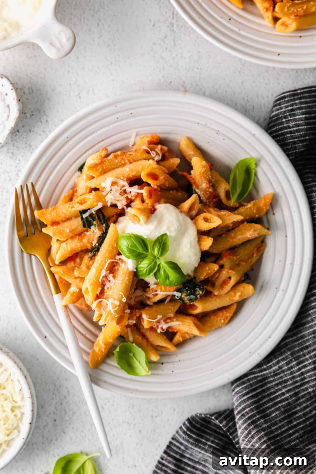 Whipped ricotta pasta served on a white plate, garnished with fresh herbs