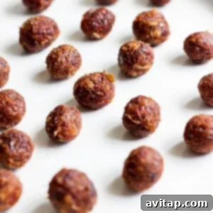 Small, perfectly rolled balls of date caramel resting neatly on a white plate, ready to be coated in chocolate.
