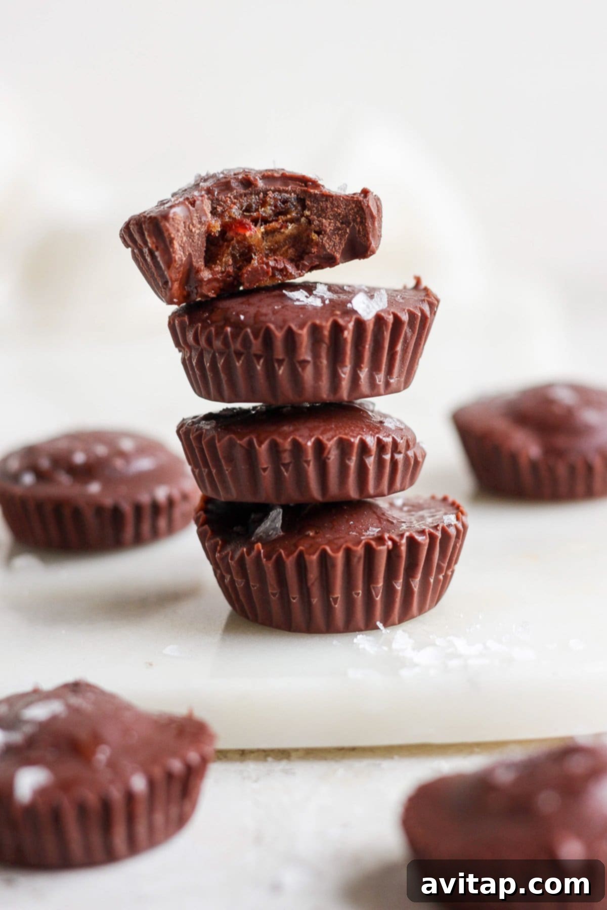 A beautifully arranged stack of homemade chocolate peanut butter cups on a rustic wooden cutting board, inviting a healthy indulgence.