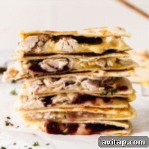 A stack of leftover Thanksgiving turkey quesadillas with cranberry sauce.