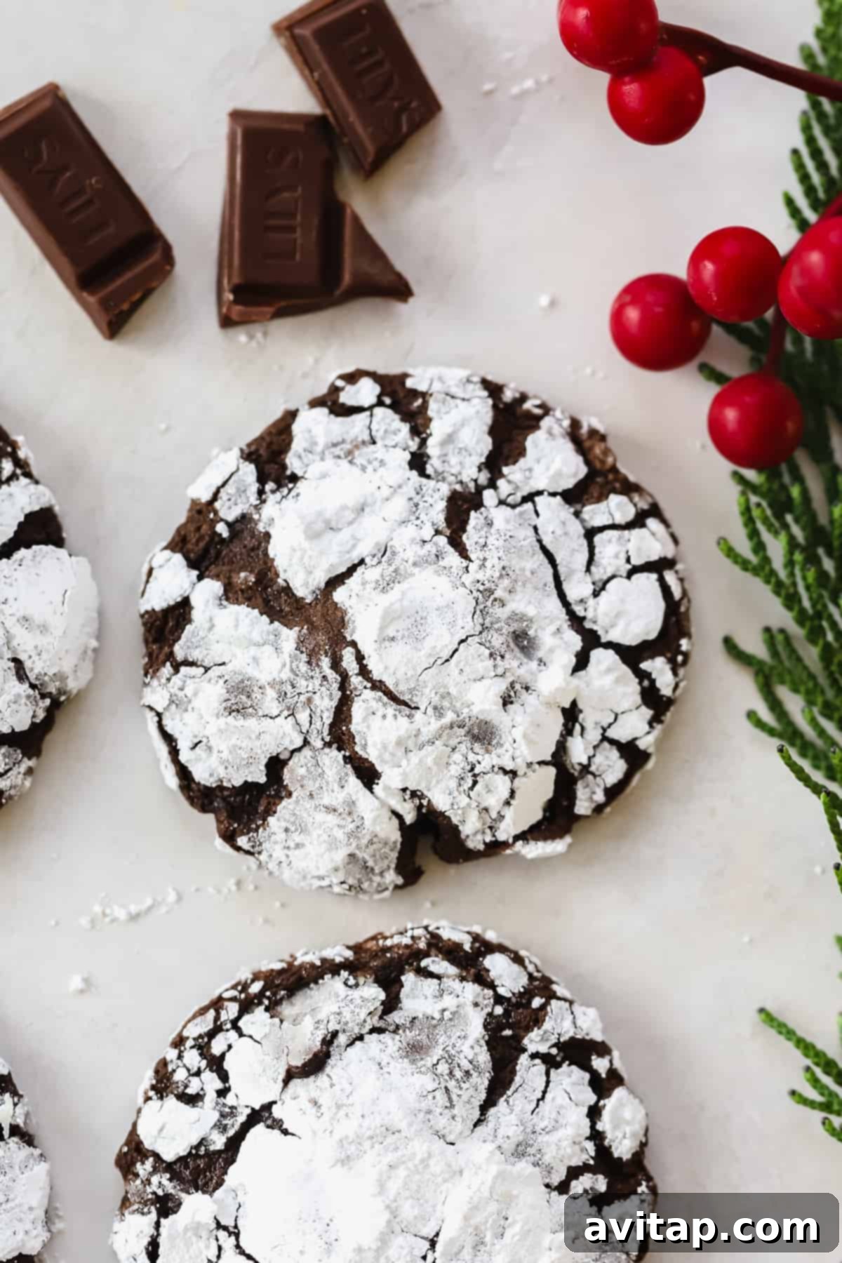 Decadent Chocolate Crinkle Cookie: Chewy, Fudgy, and Coated with Powdered Sugar A perfectly baked chocolate crinkle cookie dusted with powdered sugar, resting on a white plate, ready to be enjoyed.