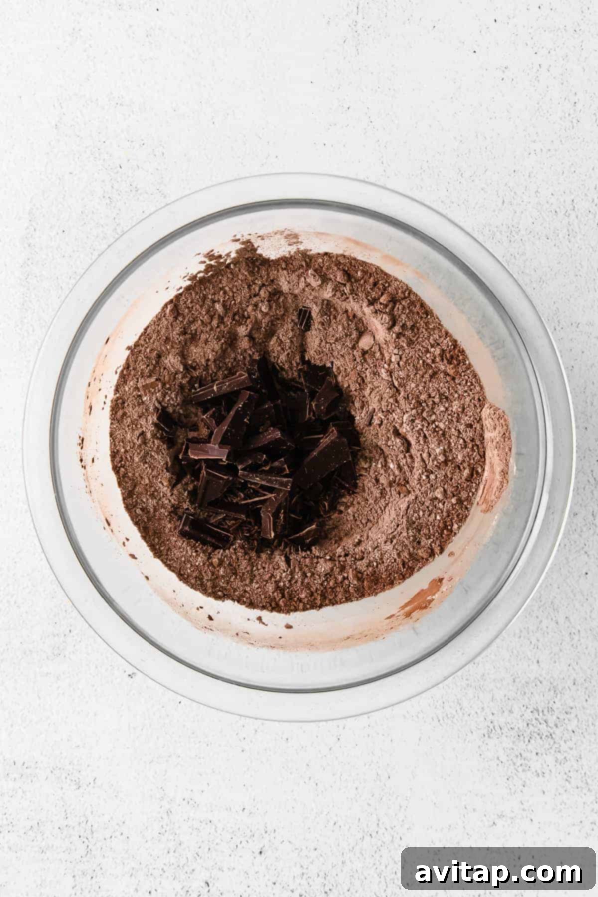 Dry Ingredients for Chocolate Crinkle Cookies A mixing bowl filled with dry ingredients for cookies, including flour and cocoa powder, ready for whisking.
