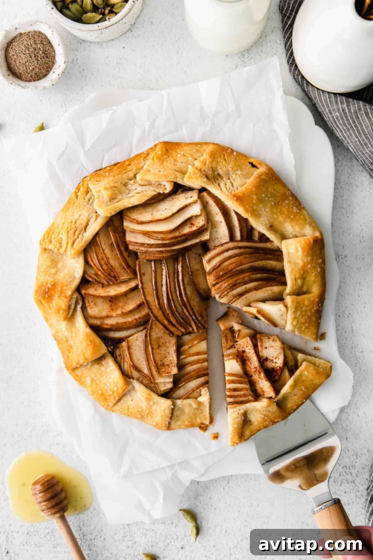 Rustic Honey-Kissed Pear Tart 8 A slice of pear galette being carefully lifted with a spatula, showcasing its crispy crust and flavorful filling.