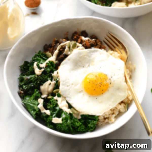 A bowl of rice and kale with an egg on top.