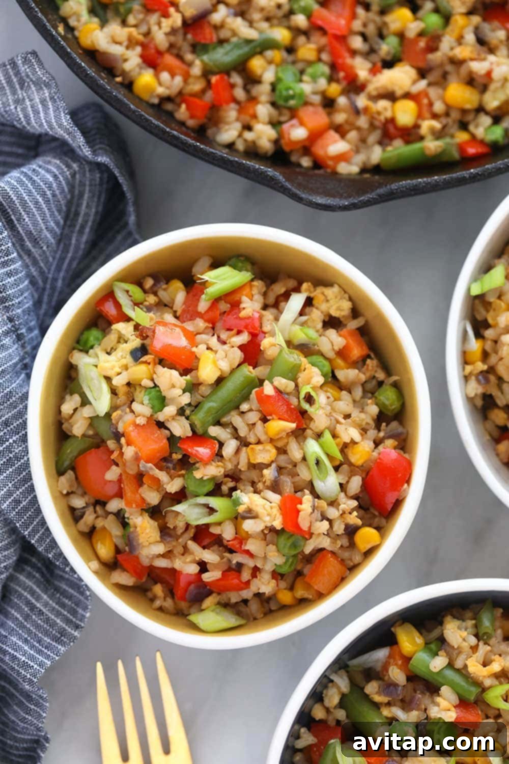 A vibrant bowl of healthy vegetable fried rice, garnished and ready to serve.