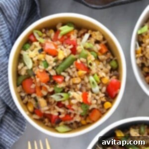 Three bowls of fried rice with vegetables.