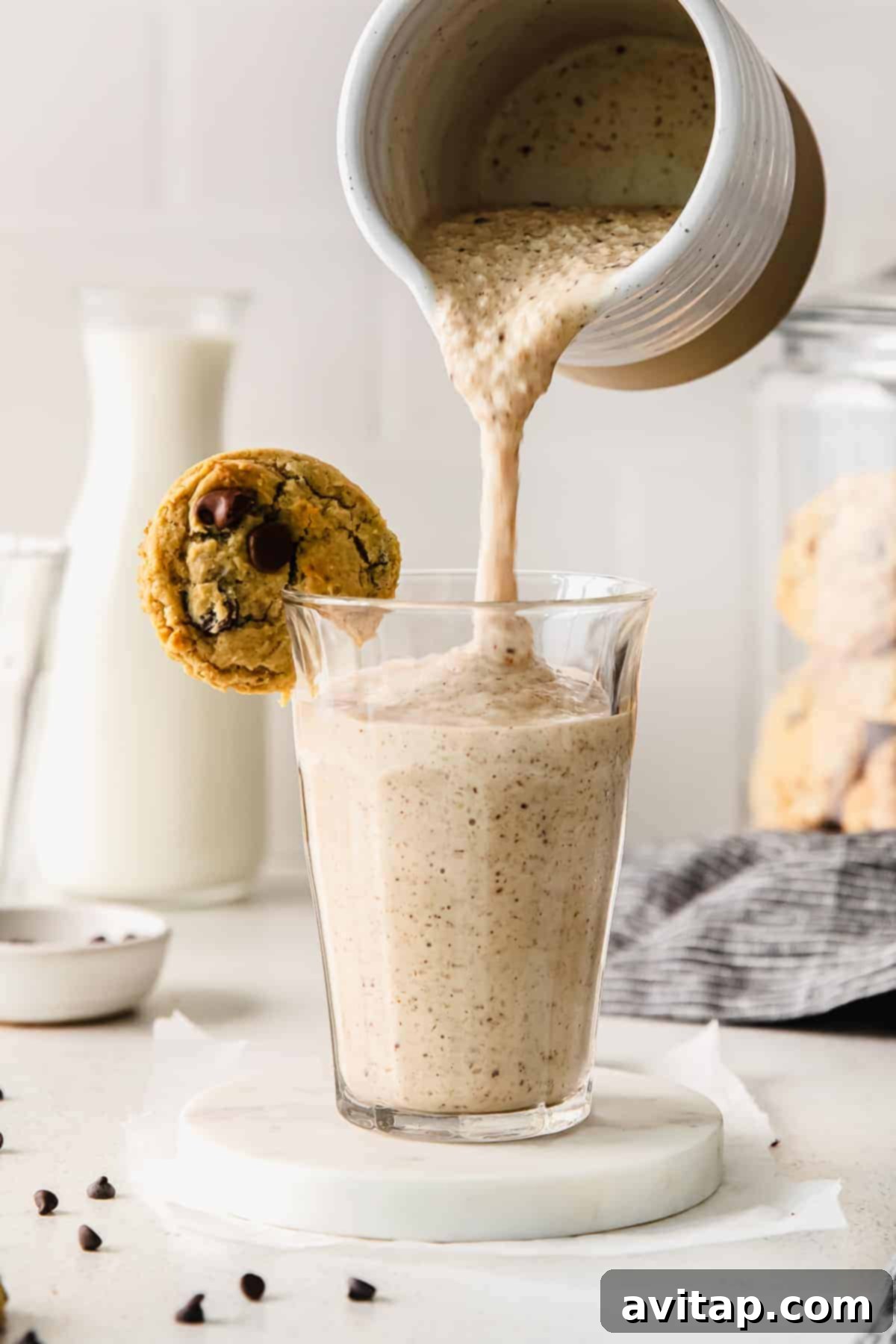 Decadent Chocolate Chip Cookie Dough Smoothie 6 A thick, creamy cookie dough smoothie being poured from a blender into a tall glass, ready to be enjoyed.