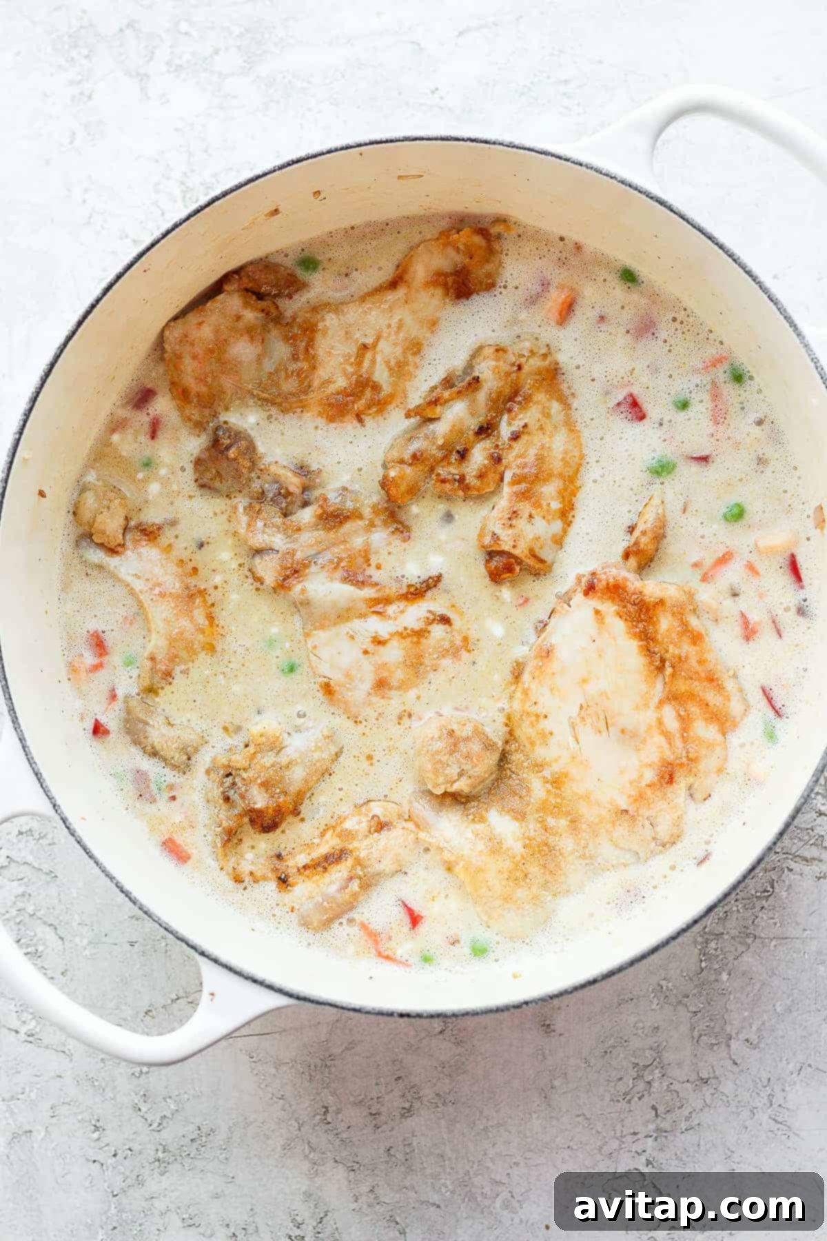Delicious one-pot chicken and rice simmering in a Dutch oven, rich with curry sauce and vegetables.