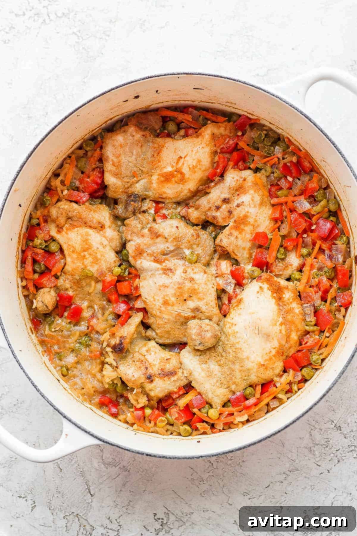 The finished one-pot chicken and rice dish, perfectly cooked and garnished, ready to be served from the Dutch oven.