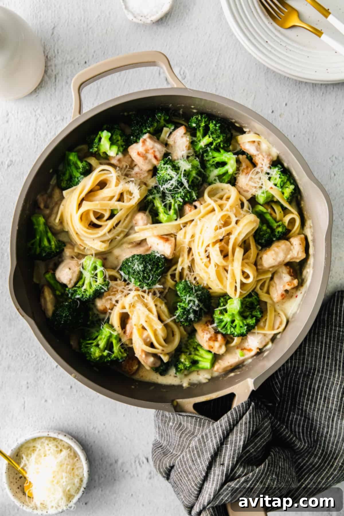 A vibrant dish of chicken broccoli alfredo in a large skillet, ready to be served.
