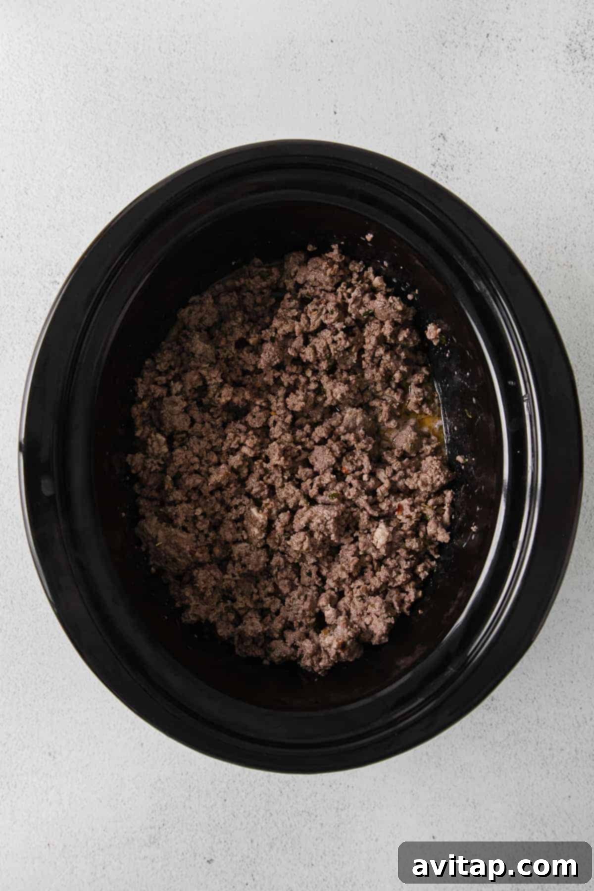 Sautéed Meat in the Slow Cooker Partially browned ground beef and pork simmering in a slow cooker, ready for the next steps.