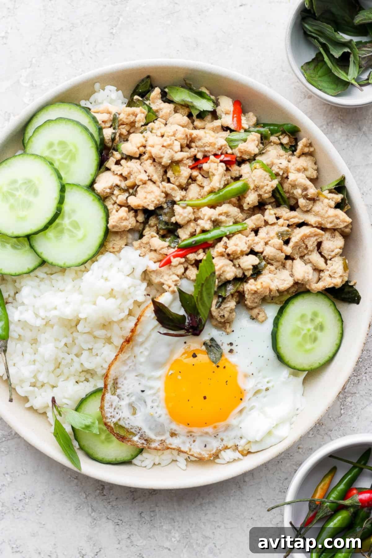 Authentic Pad Krapow: A Flavorful Thai Basil Chicken Stir Fry A beautifully presented bowl of homemade Pad Krapow (Thai Basil Chicken Stir Fry), garnished with vibrant fresh basil and a perfectly fried egg, ready to be enjoyed.