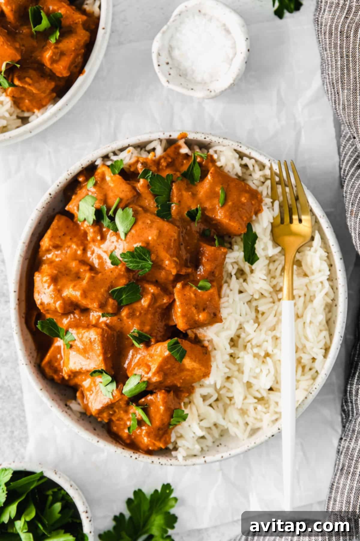 Irresistible Butter Chicken 2 Butter chicken in a bowl served over rice.