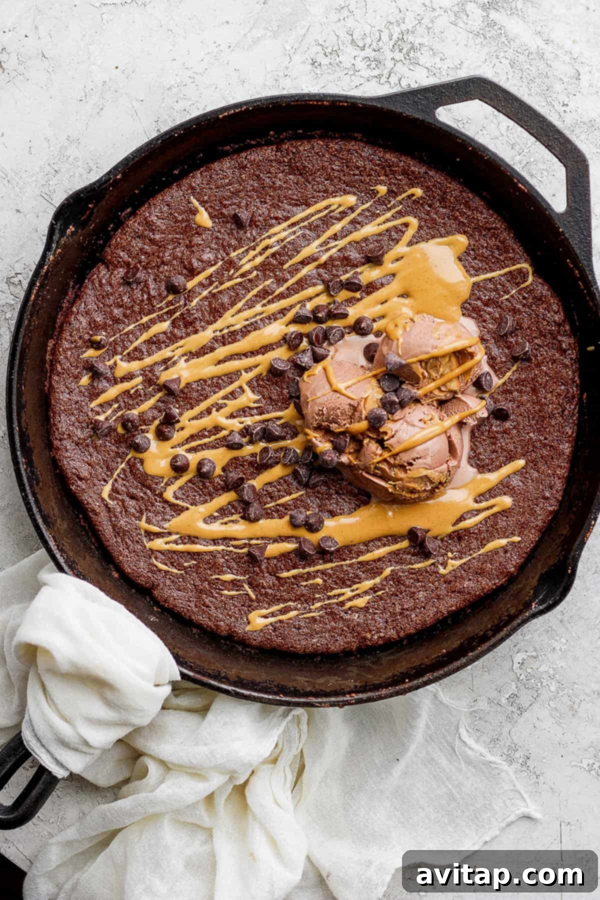 Decadent Flourless Chocolate Skillet Cake with Ice Cream Flourless Chocolate Skillet Cake topped with creamy ice cream and shimmering mini chocolate chips, ready to be enjoyed.