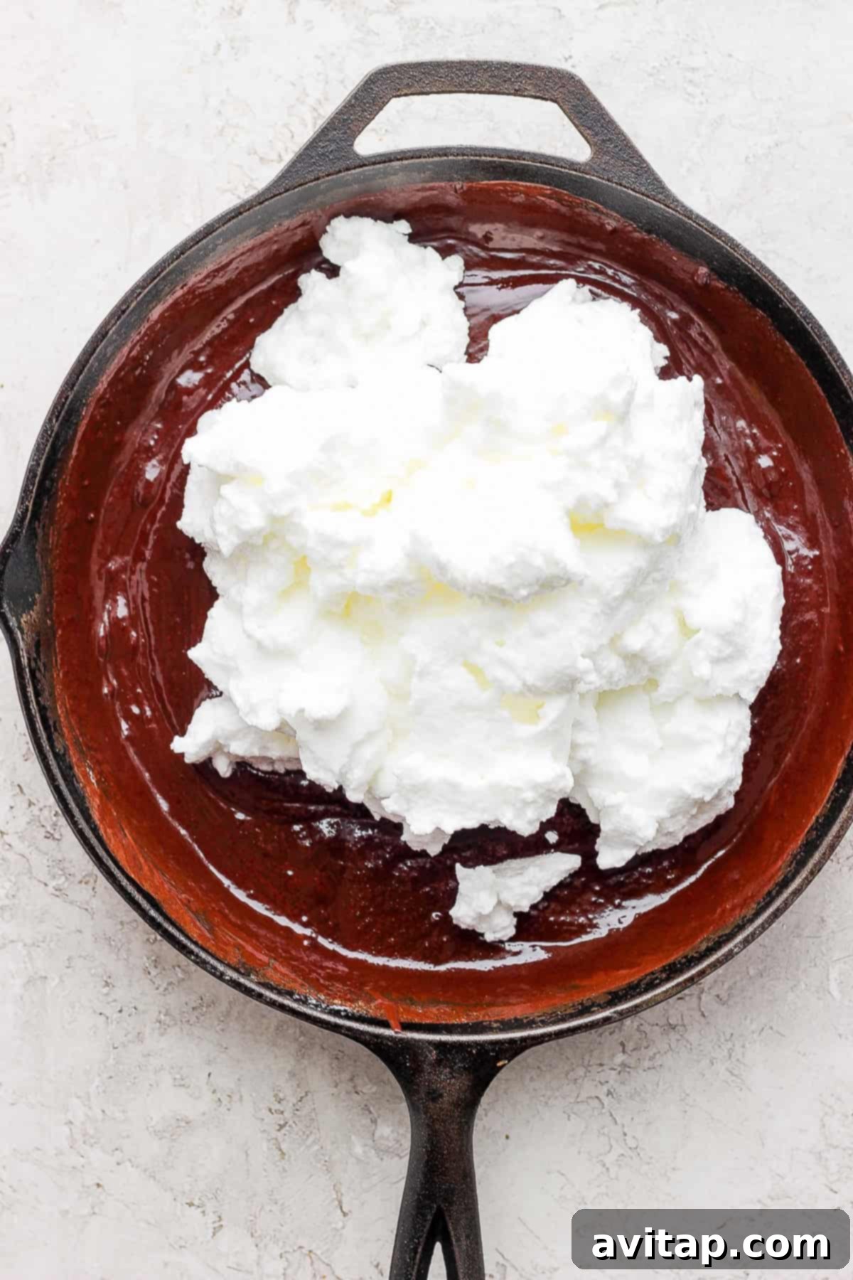Folding Egg Whites into Batter Fluffy egg whites gently folded into the rich chocolate skillet cake batter, creating a beautifully airy mixture.