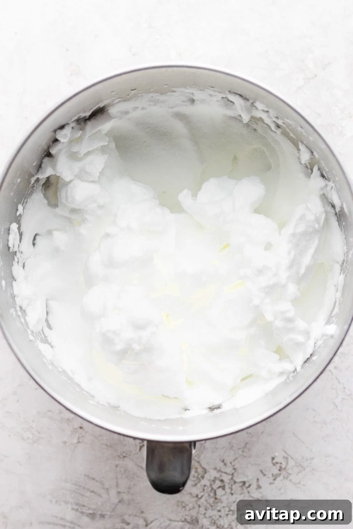 Key Ingredient: Separated Egg Whites Freshly separated egg whites in a clean, large metal mixing bowl, ready for whisking to stiff peaks.