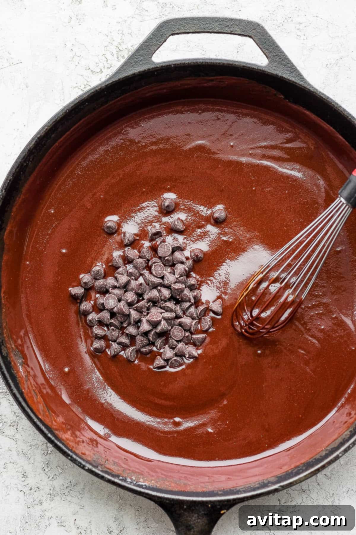 Skillet Cake Batter Ready for Oven Smooth, rich flourless chocolate skillet cake batter evenly spread in a cast iron skillet, ready for baking.