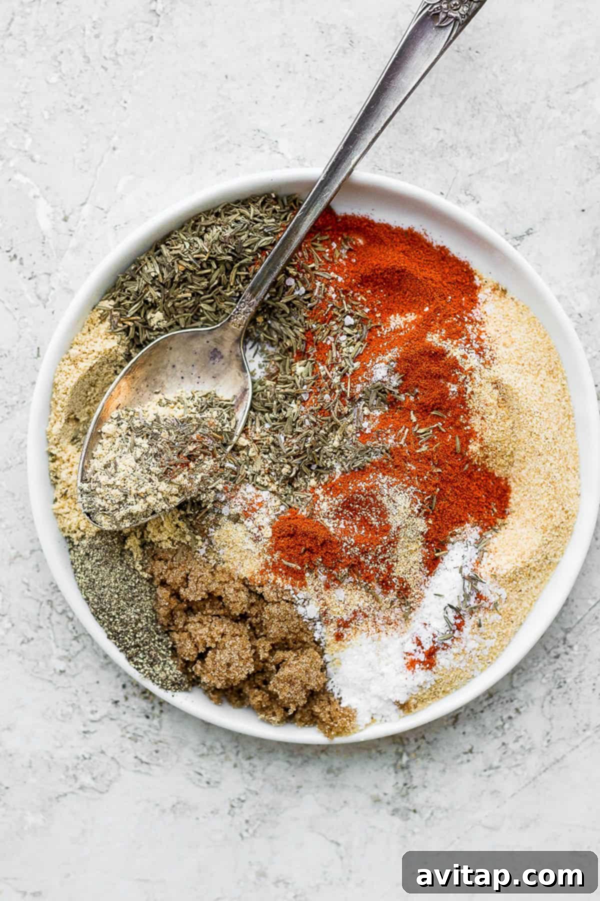 Perfect Salmon Seasonings 3 Close-up of the seven individual spices laid out before being mixed into the homemade salmon seasoning: paprika, garlic powder, brown sugar, kosher salt, dried thyme, mustard powder, and black pepper.