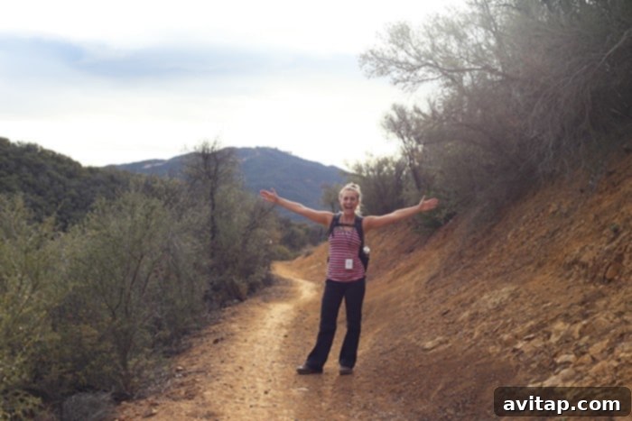 Friends enjoying a scenic hike on a Malibu trail, surrounded by lush greenery and expansive views under a clear sky.