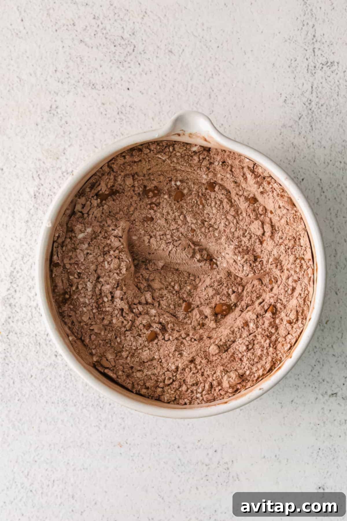 A bowl containing dry ingredients like flour and cocoa powder, ready for mixing.