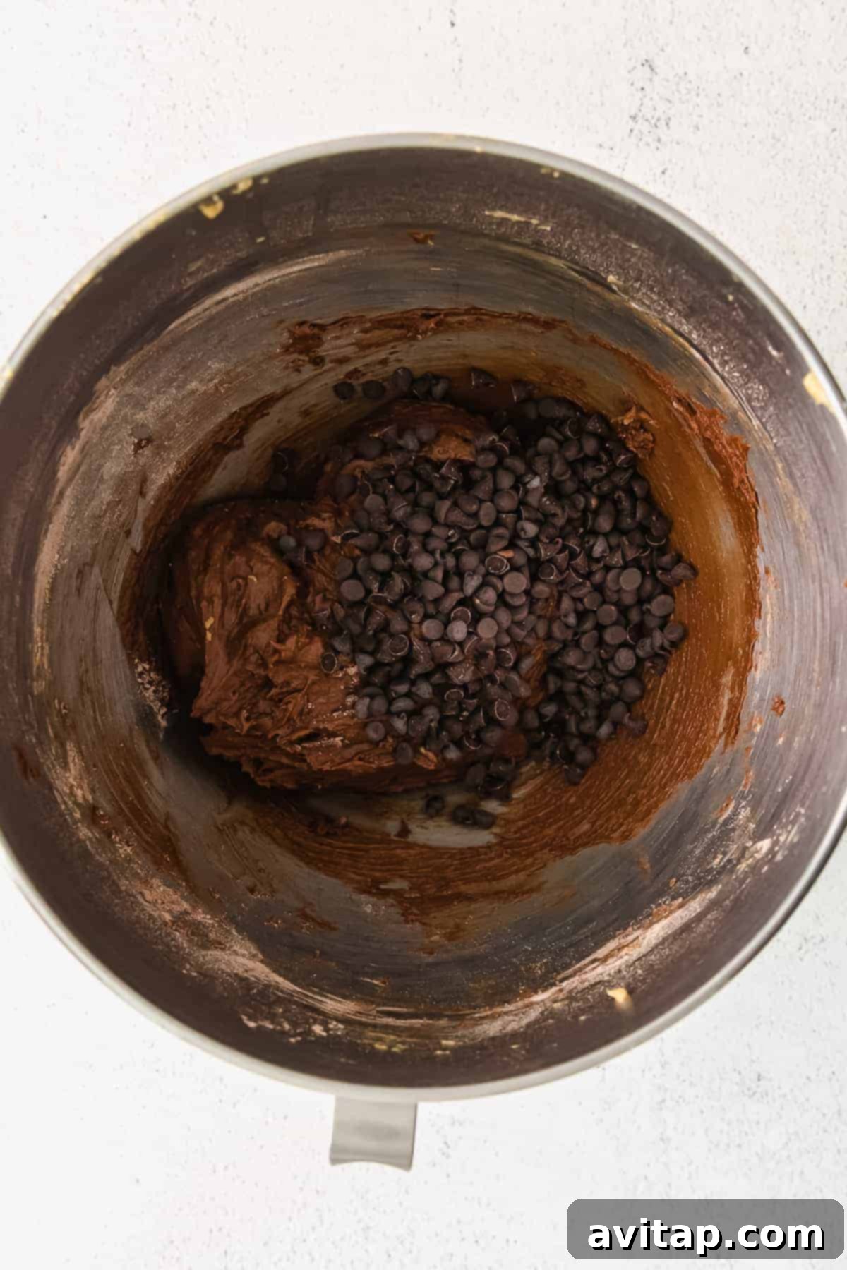 Smooth, rich chocolate donut batter in a mixing bowl, ready for piping.