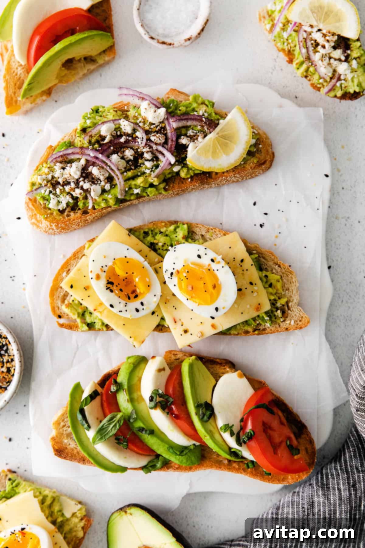 3 slices of avocado toast on a plate, featuring Mediterranean, Caprese, and Egg varieties