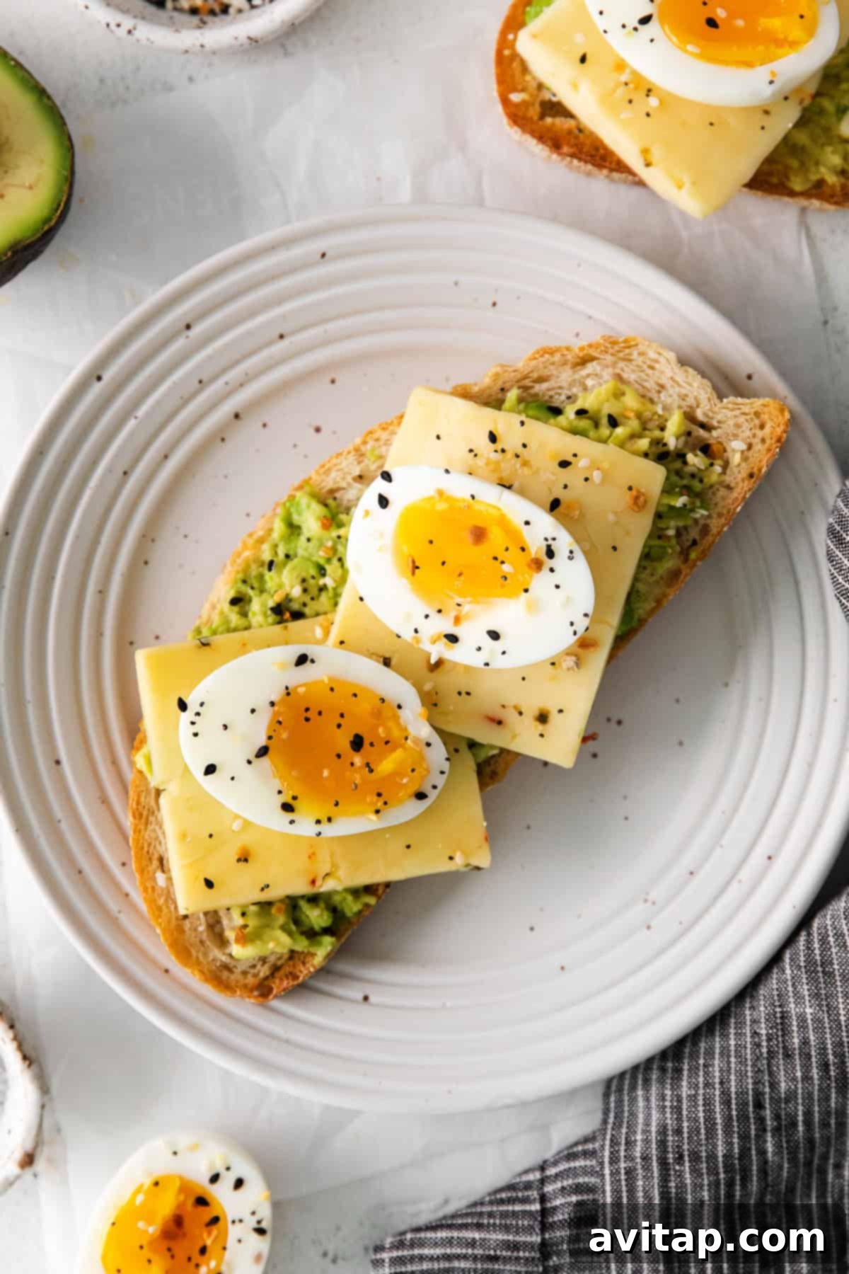 Soft boiled eggs resting on top of avocado toast