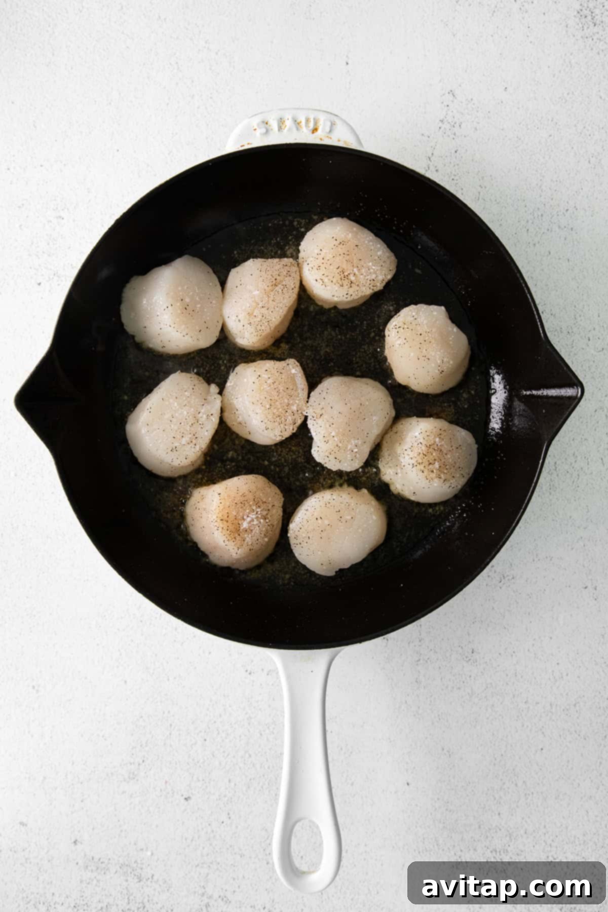 Scallops searing in a hot cast iron pan. 