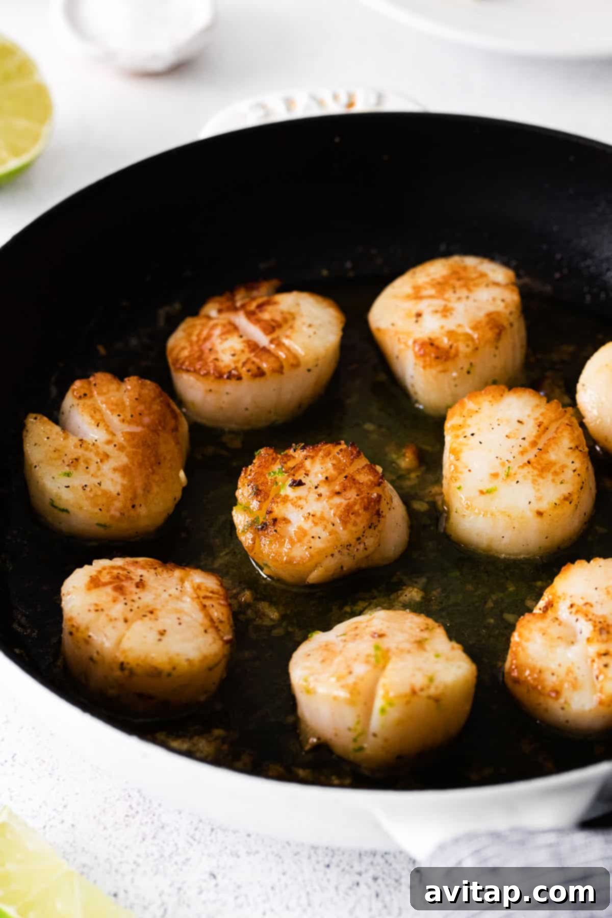 Cooked scallops in a cast iron pan, ready for plating. 