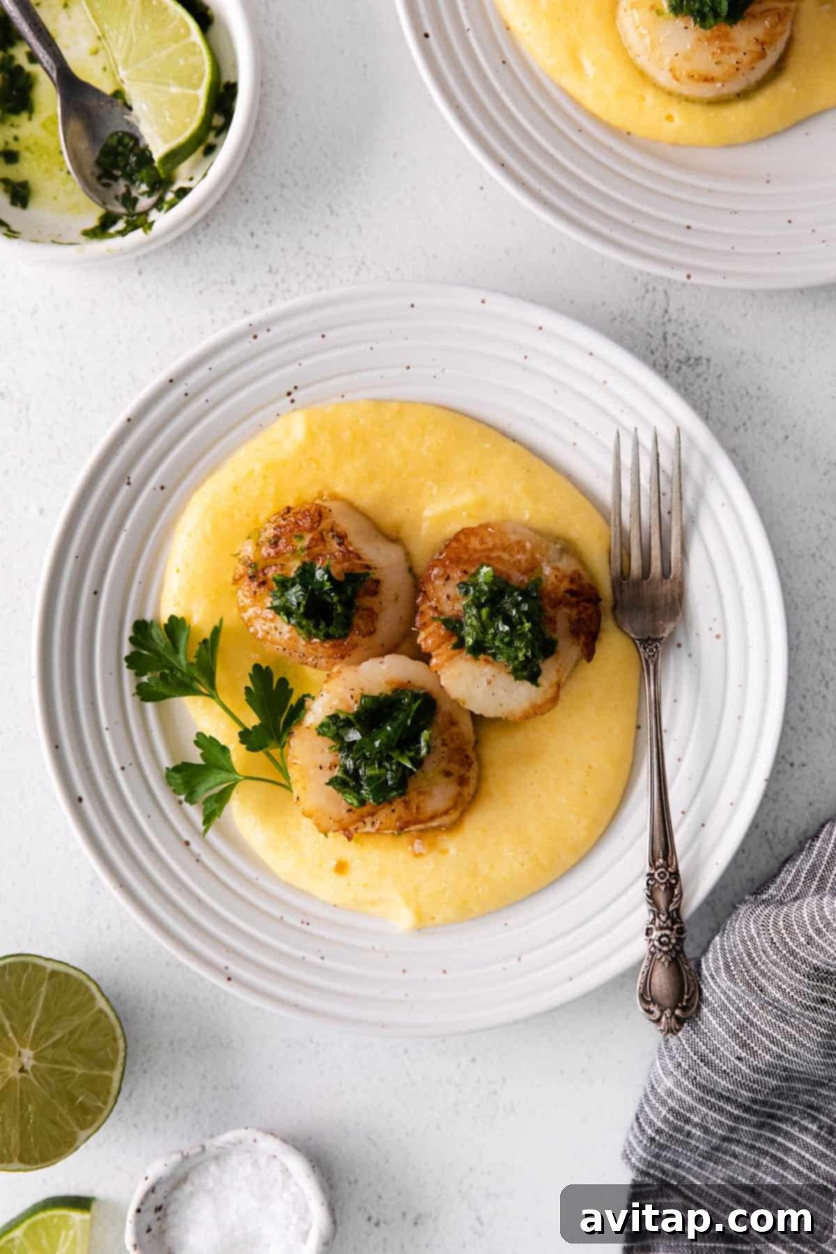 Pan seared scallops served over polenta with fresh herbs. 