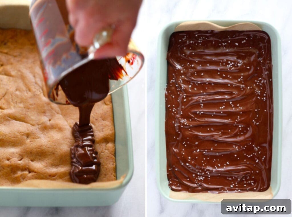 Pouring melted chocolate topping over homemade peanut butter protein bars in a baking dish.