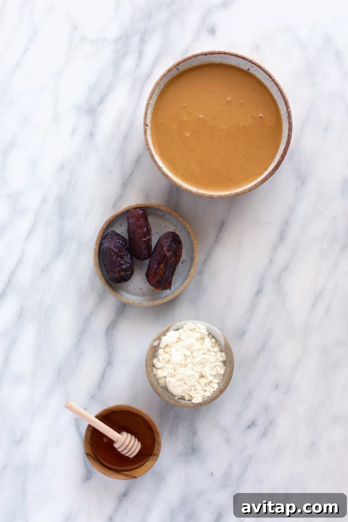 All natural ingredients for homemade peanut butter protein bars laid out on a surface.