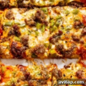 Marie's Perfect Homemade Pizza Dough 2 A close-up view of a freshly baked, cheesy homemade pizza with Italian sausage and green peppers.