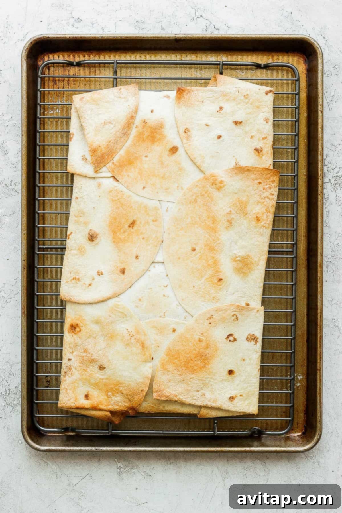 A golden brown, perfectly crispy sheet pan quesadilla, freshly baked and ready to be sliced, on a baking sheet.