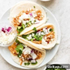 Plated chicken tinga tacos with toppings.