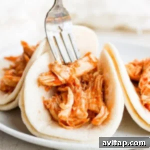 Chicken tinga tacos ready for toppings on warm tortillas.