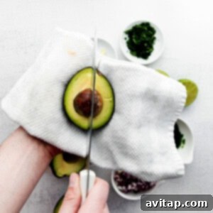 Slicing an avocado in half, showing the pit.