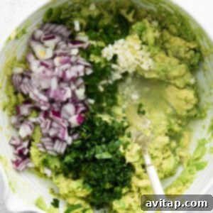 Bowl with guacamole ingredients mixed together.