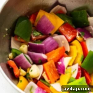 A bowl filled with freshly chopped bell peppers and red onions.