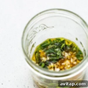 A glass jar containing a mixture of herbs and spices for the veggie marinade.