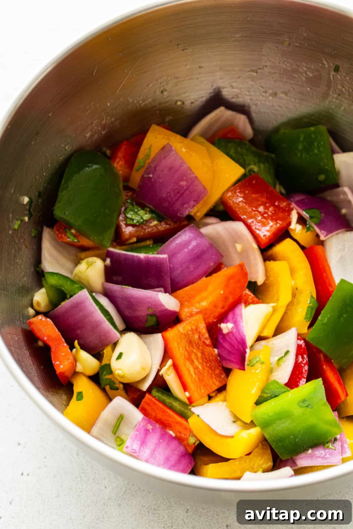 A vibrant bowl of rainbow vegetables marinating in a flavorful sauce.