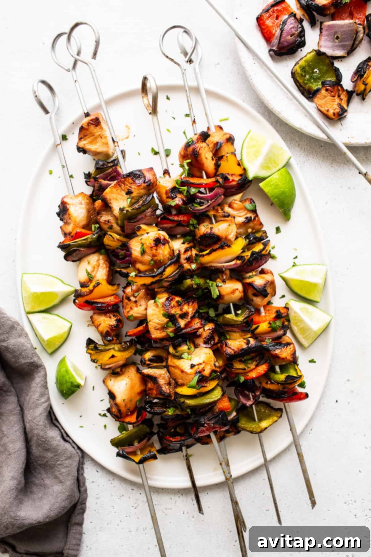 Perfectly grilled chicken kabobs resting on a clean white plate.